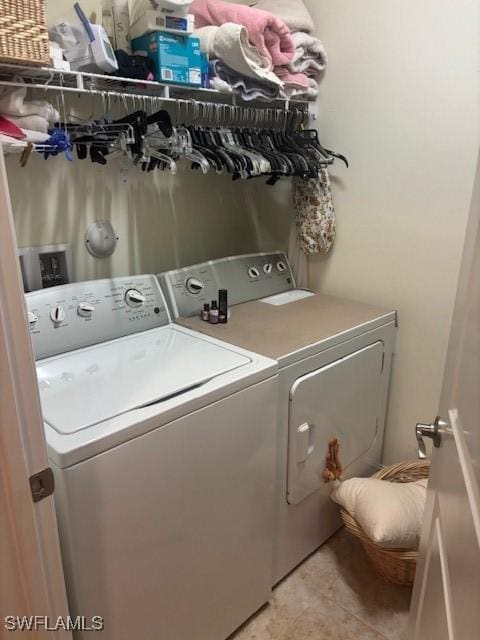 laundry area featuring laundry area, light tile patterned flooring, and washing machine and clothes dryer