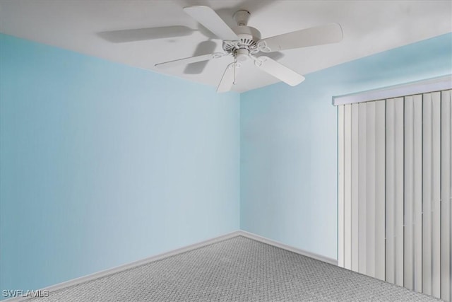 carpeted spare room with a ceiling fan and baseboards