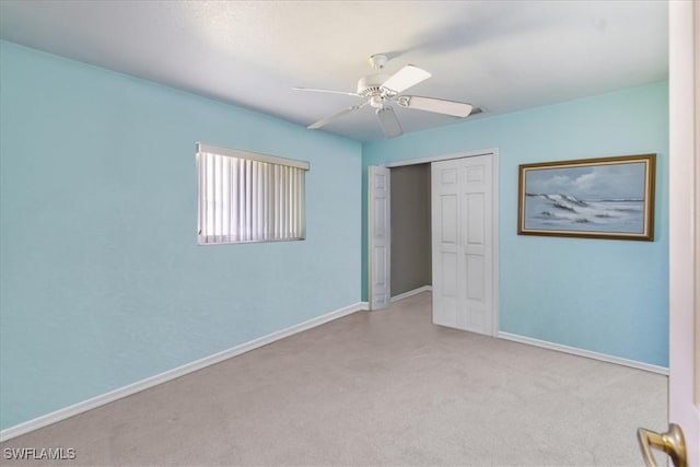 unfurnished bedroom featuring a ceiling fan, carpet, a closet, and baseboards