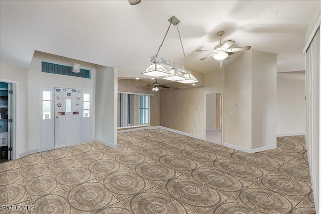 interior space featuring vaulted ceiling, a ceiling fan, and baseboards