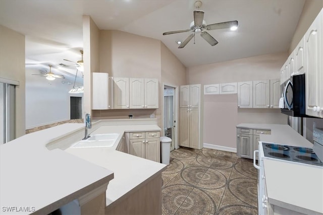 kitchen featuring a peninsula, electric range, a sink, vaulted ceiling, and stainless steel microwave