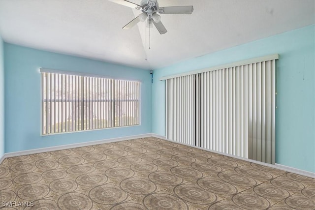 unfurnished room with baseboards and a ceiling fan