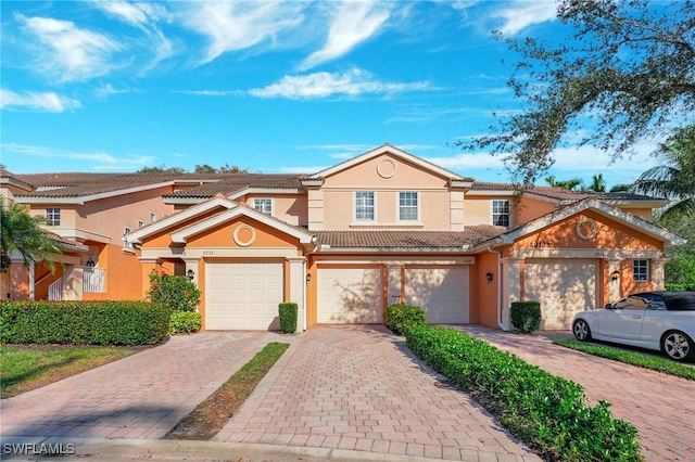 view of front of home with decorative driveway, a tile roof, and stucco siding