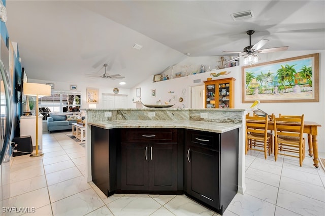 kitchen featuring lofted ceiling, visible vents, open floor plan, marble finish floor, and light stone countertops