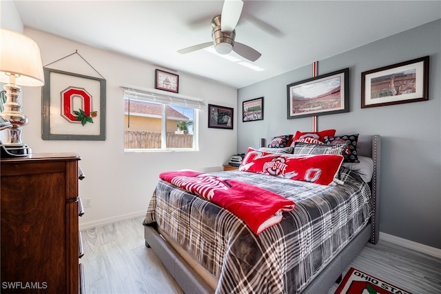 bedroom with a ceiling fan, baseboards, and wood finished floors