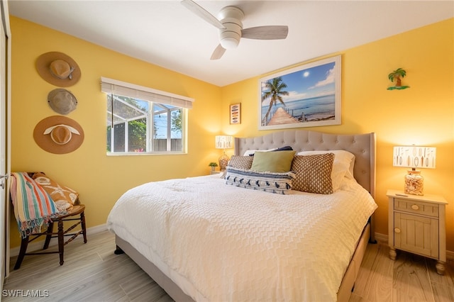 bedroom featuring light wood finished floors, a ceiling fan, and baseboards