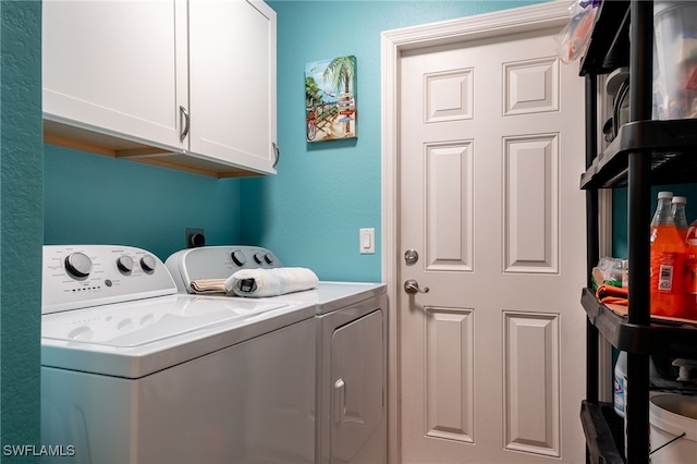 clothes washing area featuring cabinet space and independent washer and dryer