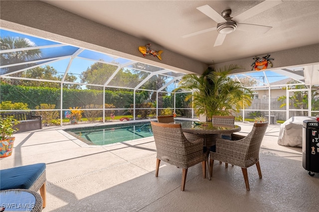 pool with a ceiling fan, glass enclosure, and a patio