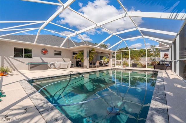 view of swimming pool with glass enclosure, fence, a fenced in pool, and a patio