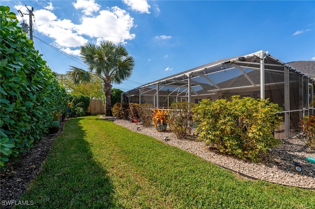 view of yard with glass enclosure and fence