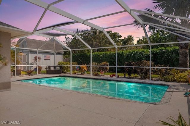 pool at dusk featuring a patio and an outdoor pool