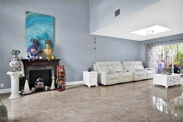 living area with marble finish floor, a premium fireplace, visible vents, and baseboards