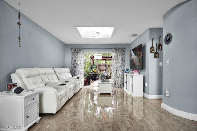 living area featuring a skylight, baseboards, visible vents, and marble finish floor