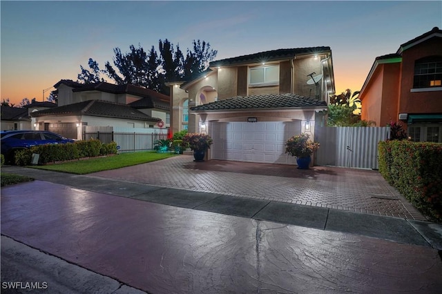 view of front of property with a tile roof, stucco siding, driveway, and fence