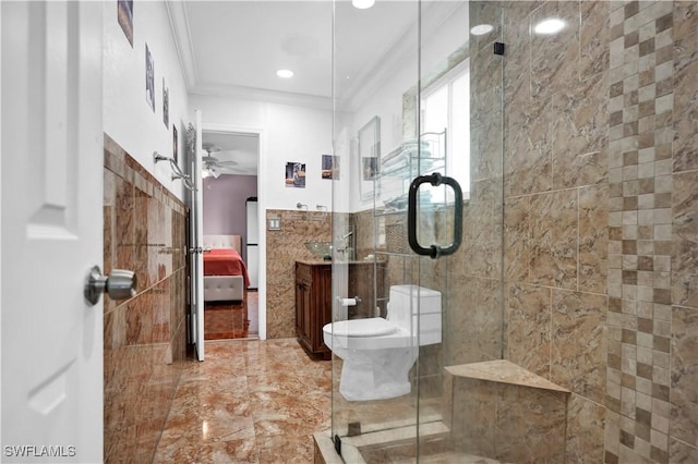 bathroom with toilet, tile walls, ornamental molding, a stall shower, and ensuite bath