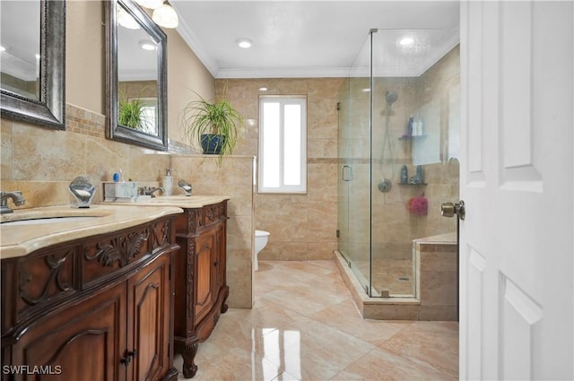 bathroom with tile walls, two vanities, ornamental molding, a sink, and a shower stall