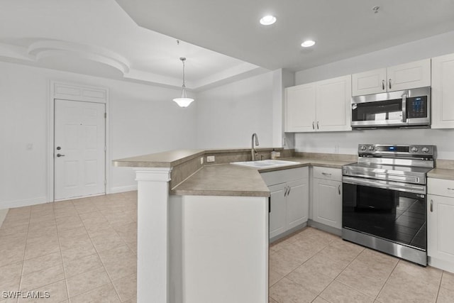 kitchen with decorative light fixtures, a peninsula, stainless steel appliances, white cabinetry, and a sink