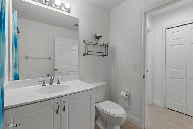 bathroom featuring tile patterned flooring, baseboards, vanity, and toilet