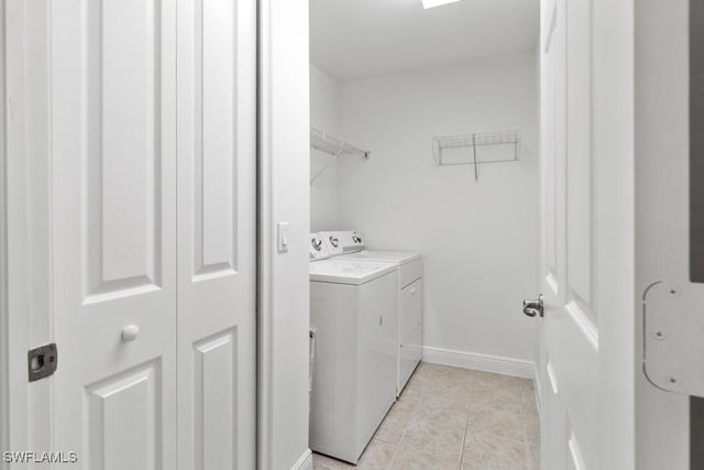 laundry area featuring light tile patterned floors, laundry area, independent washer and dryer, and baseboards