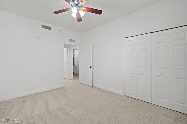 unfurnished bedroom featuring light colored carpet, a closet, visible vents, and baseboards