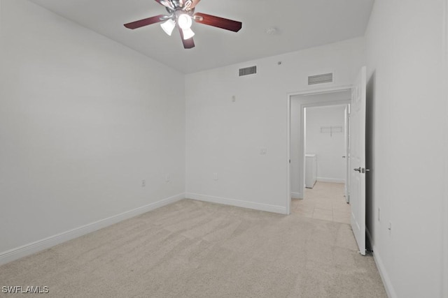 empty room featuring light carpet, baseboards, visible vents, and ceiling fan