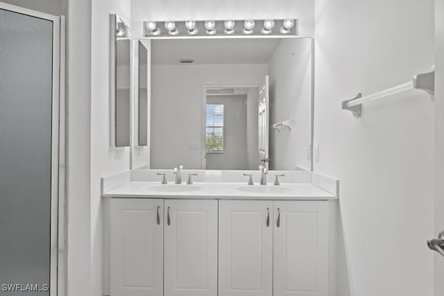 full bathroom featuring a stall shower, a sink, and double vanity