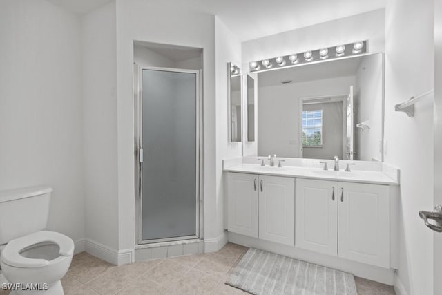 bathroom featuring toilet, a stall shower, a sink, and tile patterned floors