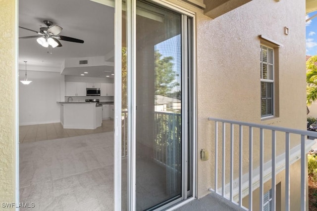 doorway to property featuring visible vents, a balcony, and stucco siding