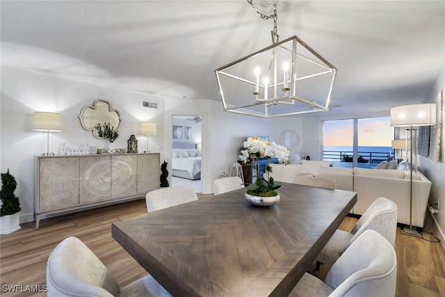 780 S Collier Blvd Unit 708, Marco Island, FL 34145 - dining room featuring a chandelier, wood finished floors, and visible vents