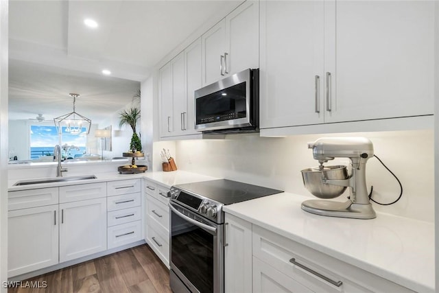 780 S Collier Blvd Unit 708, Marco Island, FL 34145 - kitchen featuring a sink, white cabinetry, light countertops, appliances with stainless steel finishes, and dark wood-type flooring
