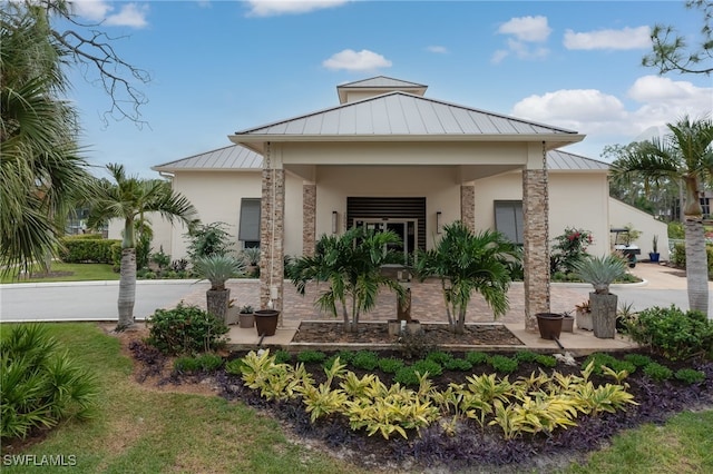 exterior space featuring metal roof, a standing seam roof, and stucco siding