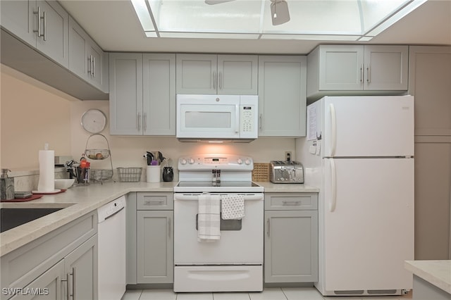 kitchen featuring gray cabinets, white appliances, and light countertops