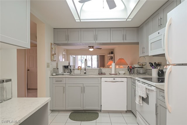 kitchen featuring ceiling fan, white appliances, a sink, light countertops, and gray cabinets