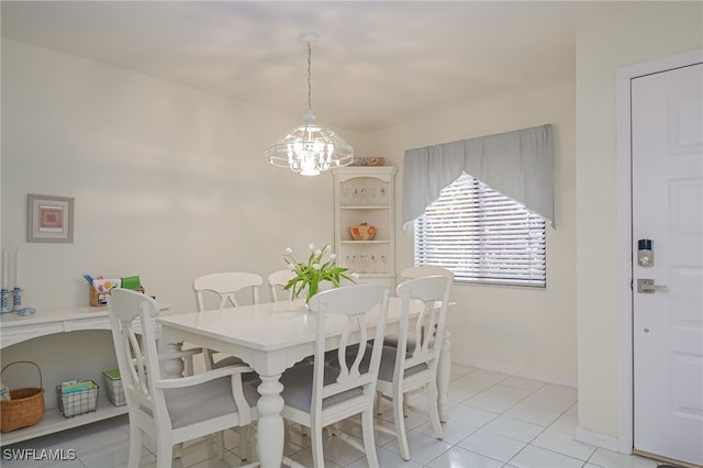 dining space with light tile patterned floors, baseboards, and a notable chandelier