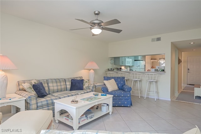 living room with ceiling fan, light tile patterned flooring, visible vents, and baseboards