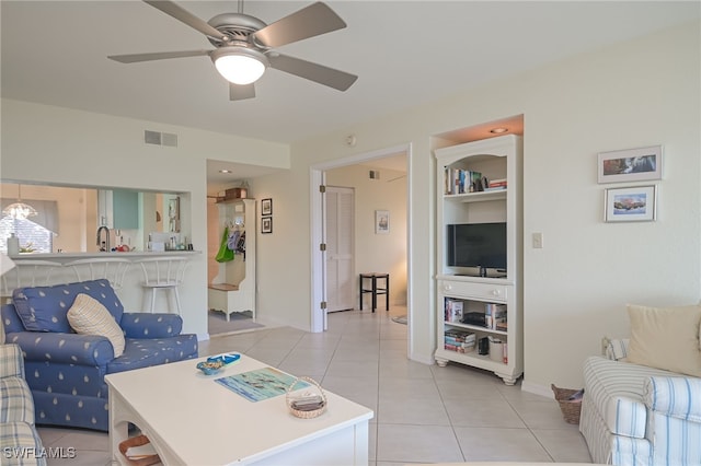 living room with light tile patterned floors, ceiling fan, built in shelves, and visible vents