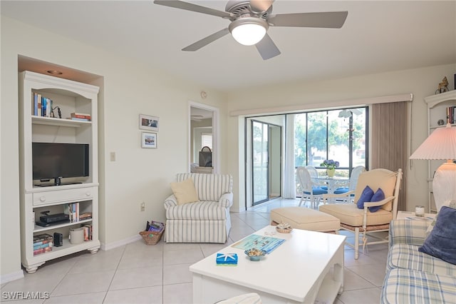 living room with light tile patterned floors, ceiling fan, and baseboards