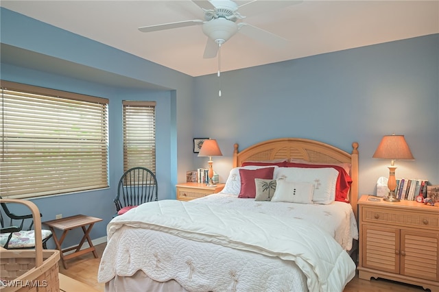 bedroom with ceiling fan, baseboards, and wood finished floors