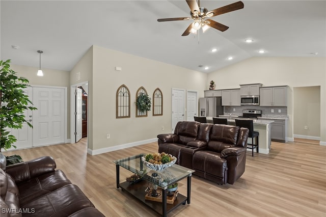 living area featuring light wood-style floors, ceiling fan, baseboards, and high vaulted ceiling