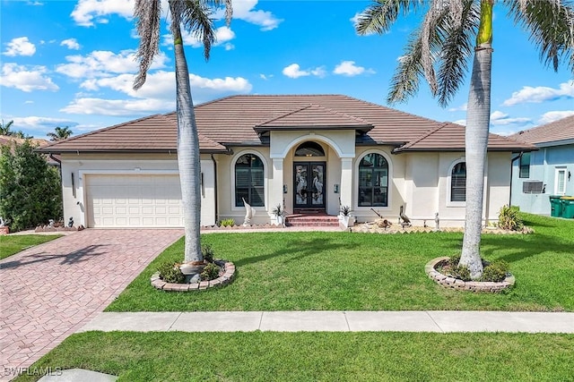 view of front of house with a garage, decorative driveway, a tiled roof, and a front lawn