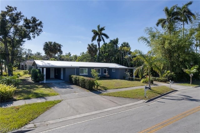 ranch-style house with aphalt driveway, a front lawn, and an attached carport