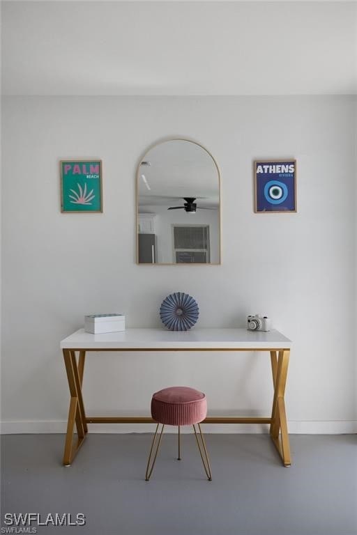 office area featuring concrete flooring and baseboards