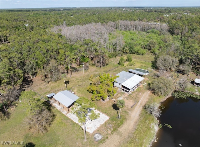 birds eye view of property with a water view and a wooded view