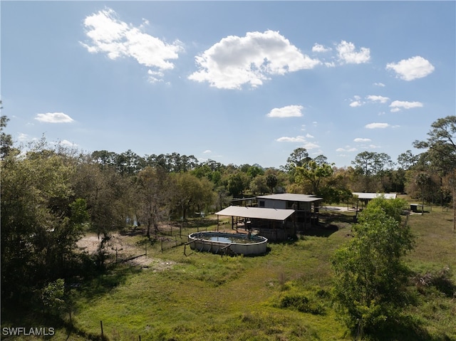 view of yard with an outdoor pool and a rural view