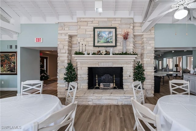 interior space with a fireplace, wood finished floors, and beamed ceiling