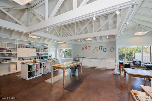 office with concrete flooring, beamed ceiling, a wealth of natural light, and track lighting