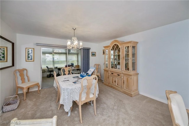 dining area with an inviting chandelier and light colored carpet