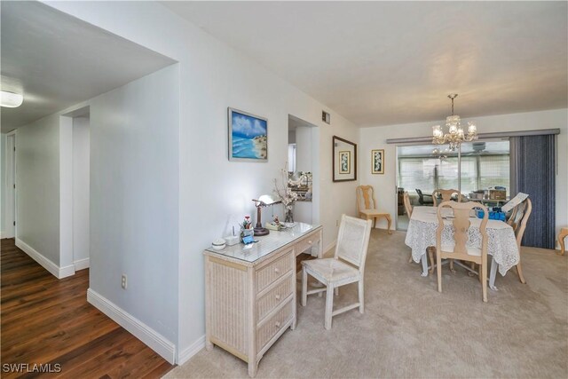 dining space with baseboards, a notable chandelier, and wood finished floors