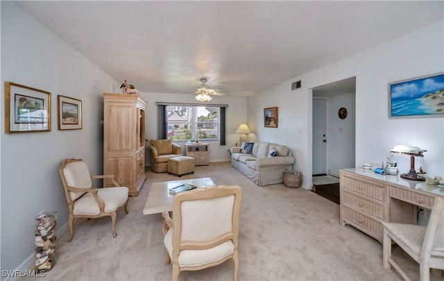 living room featuring baseboards, a ceiling fan, visible vents, and light colored carpet