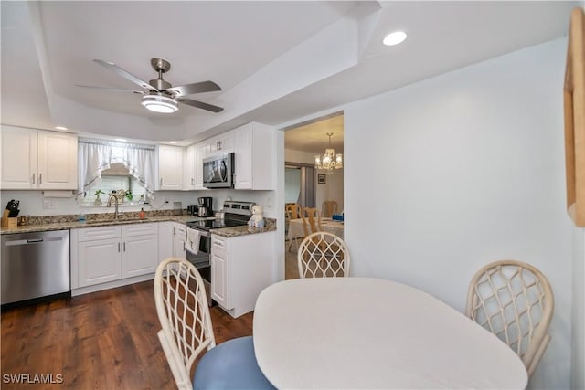 kitchen with stainless steel appliances, white cabinets, a sink, and light stone counters